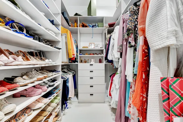 a view of walk in closet with clothes and shoes