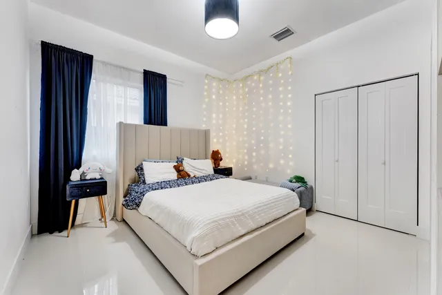 a bedroom with a bed and a potted plant