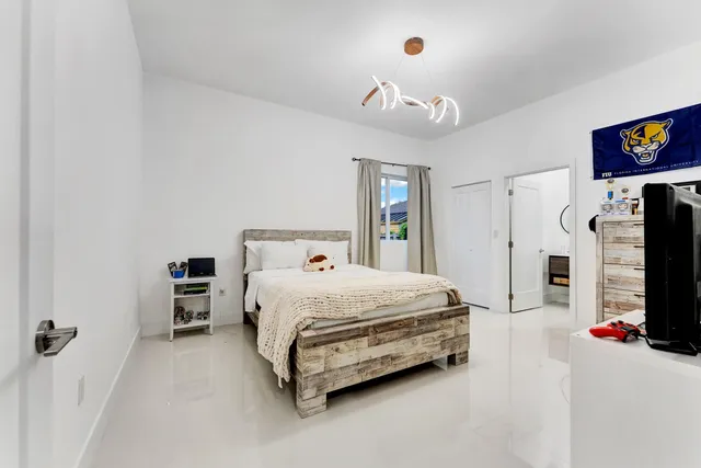 a bedroom with a bed and a flat screen tv