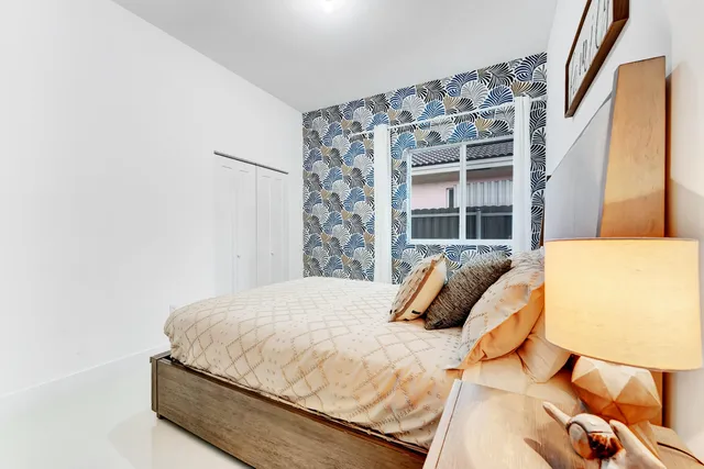 a bedroom with a bed and teddy bear on bed