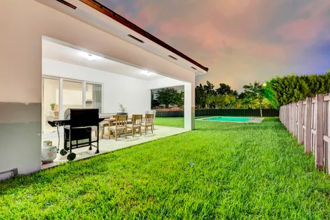 a view of a backyard with furniture and garden