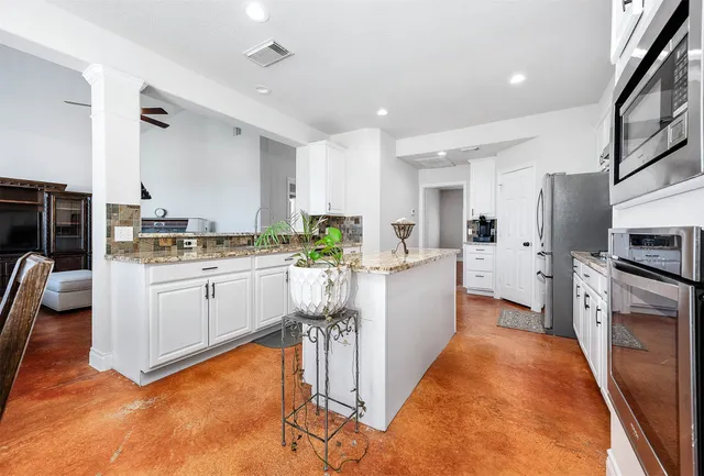 a kitchen with white cabinets and stainless steel appliances