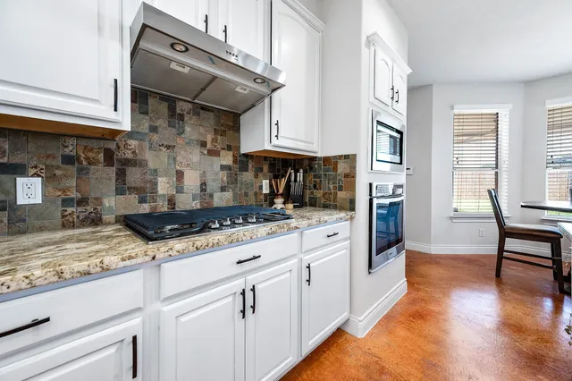 a kitchen with stainless steel appliances granite countertop a stove and a refrigerator