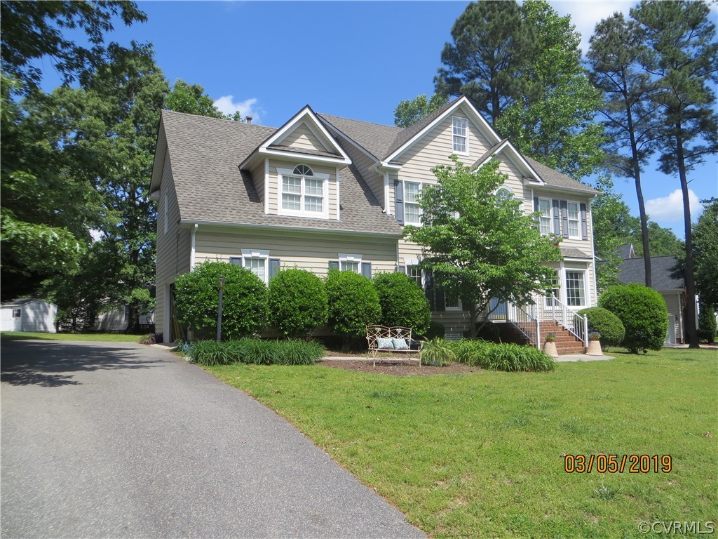 a front view of a house with a yard and potted plants