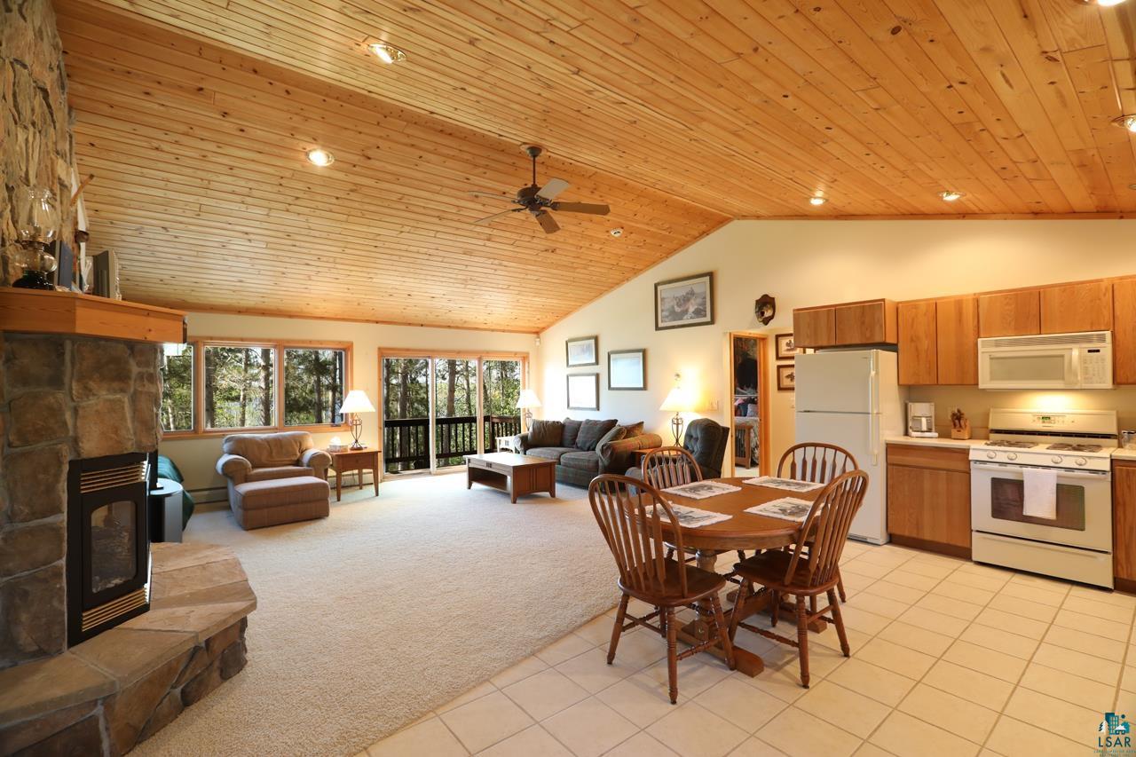 1880 Everett Bay Road Tower, MN 55790 - Photo 31 of 50 Dining area featuring wood ceiling, light tile patterned floors, ceiling fan, light colored carpet, and high vaulted ceiling