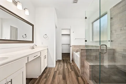 a spacious bathroom with a double vanity sink a mirror and shower