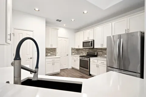 a kitchen with stainless steel appliances kitchen island granite countertop a refrigerator a stove a sink and a microwave