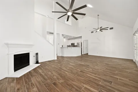 a view of empty room with wooden floor and fireplace