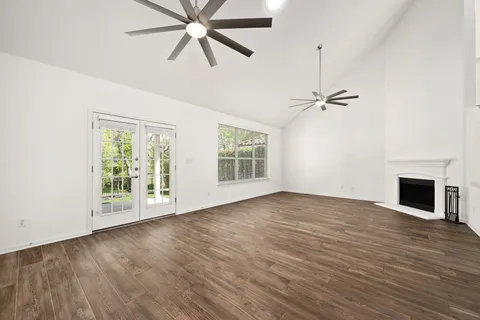 an empty room with windows fireplace and windows