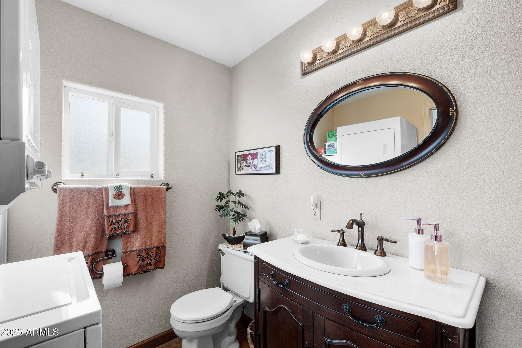 111 South Greenfield Road, Unit 588 Mesa, AZ 85206 - Photo 12 of 16 a bathroom with a toilet a sink and mirror
