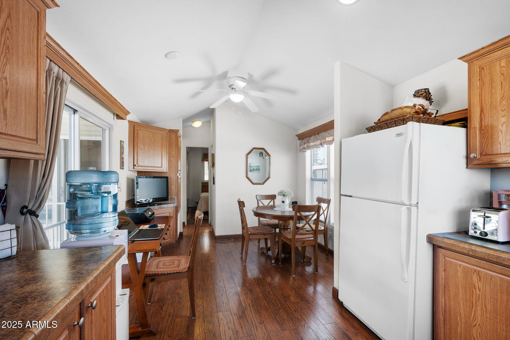 111 South Greenfield Road, Unit 588 Mesa, AZ 85206 - Photo 8 of 16 a white kitchen with stainless steel appliances granite countertop a stove a refrigerator a dining table and chairs with wooden floor