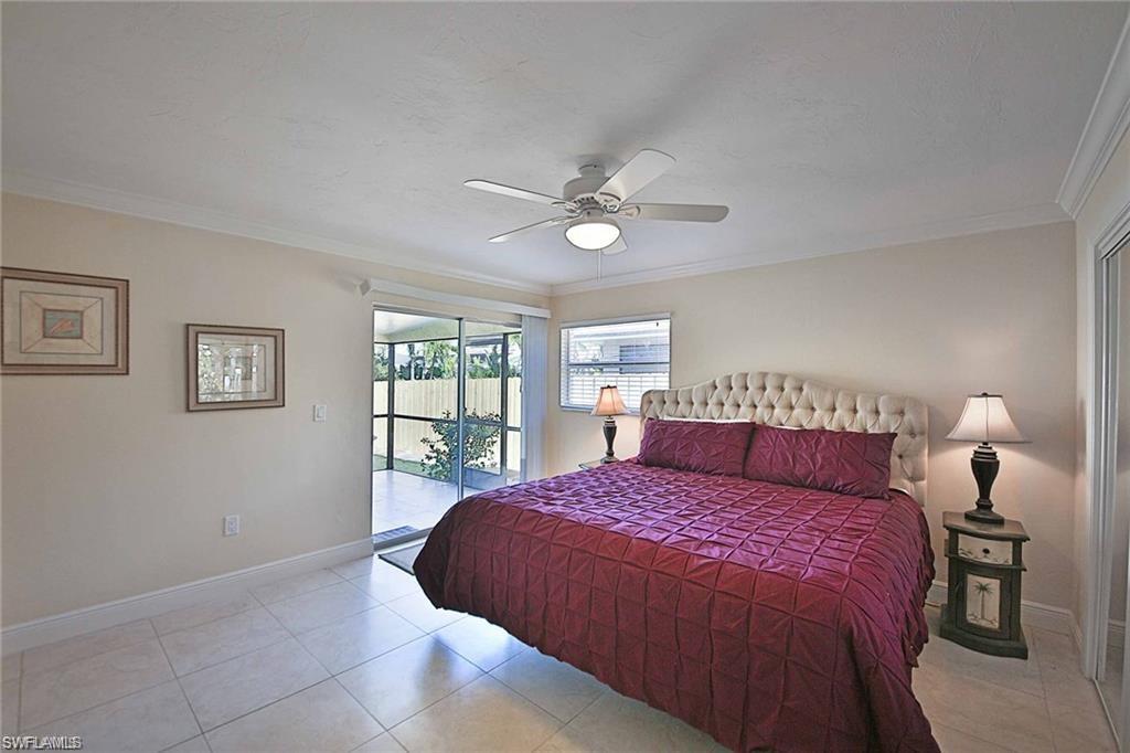 671 98th Avenue North Naples, FL 34108 - Photo 12 of 27 a bedroom with a large bed and a chandelier