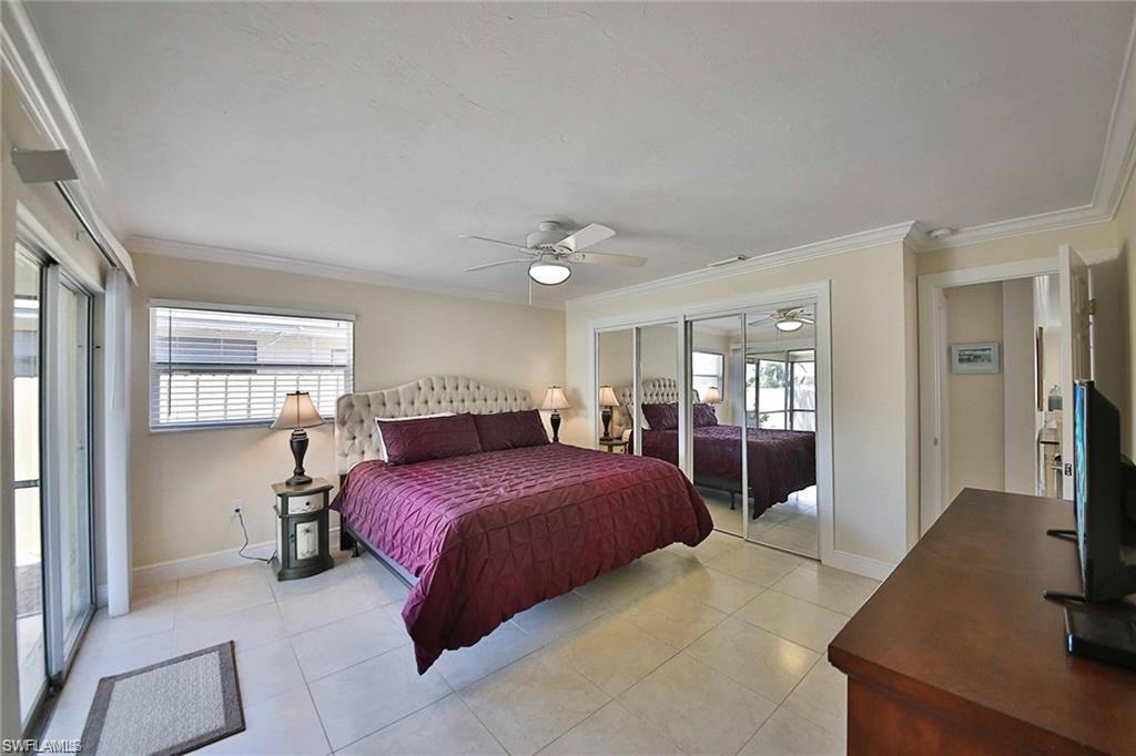 671 98th Avenue North Naples, FL 34108 - Photo 13 of 27 a bedroom with a large bed and a flat tv screen