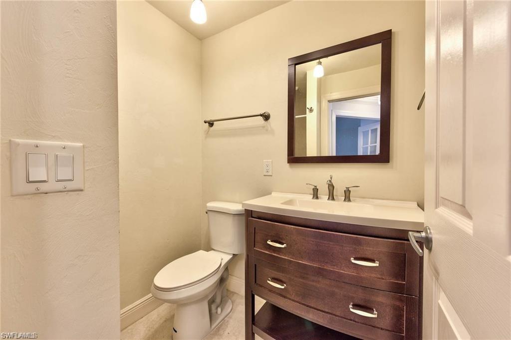 671 98th Avenue North Naples, FL 34108 - Photo 19 of 27 a bathroom with a granite countertop toilet sink and mirror