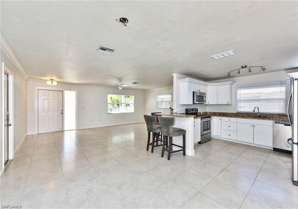 671 98th Avenue North Naples, FL 34108 - Photo 27 of 27 a large white kitchen with cabinets and chairs