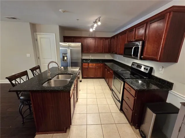 a kitchen with granite countertop sink stainless steel appliances and cabinets