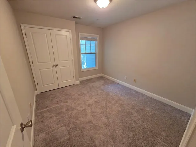 an empty room with windows and closet