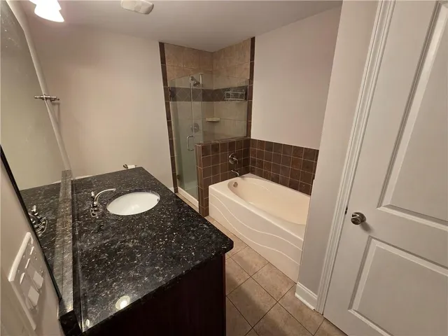 a bathroom with a granite countertop sink a mirror and a toilet