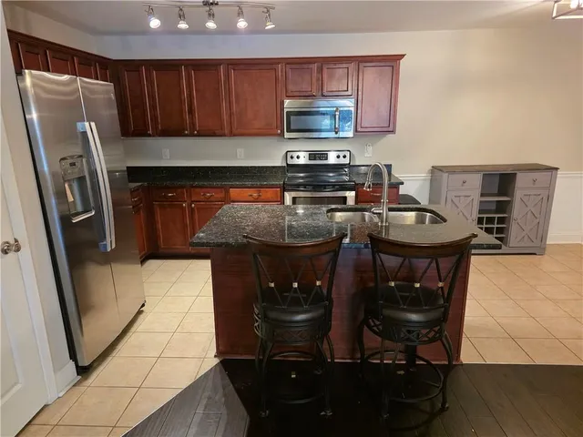 a kitchen with stainless steel appliances a stove a refrigerator a sink a stove and island