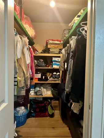 a view of walk in closet with clothes and shoes