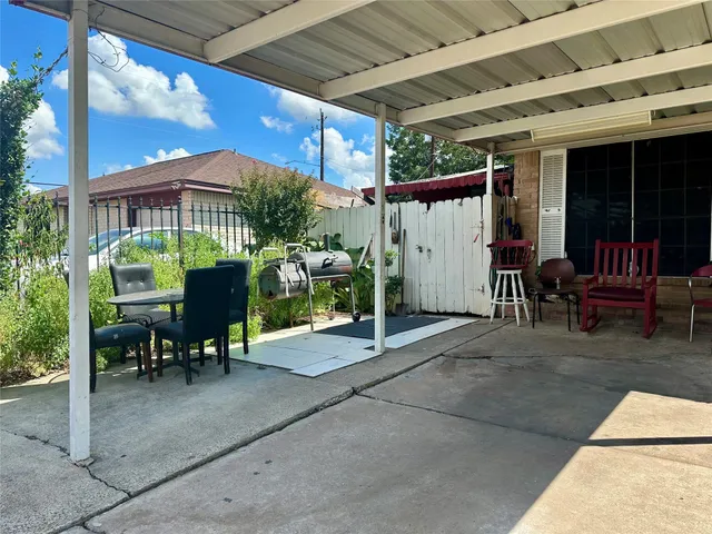 a view of a patio with a table and chairs under an umbrella