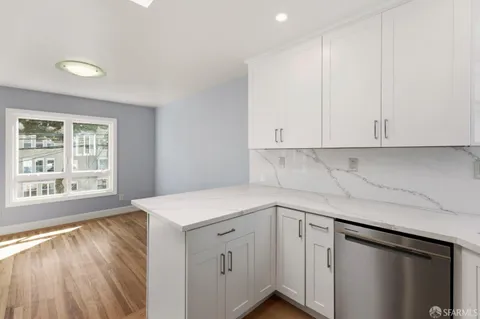 a view of a kitchen with wooden floor and cabinets