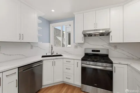 a kitchen with granite countertop white cabinets and appliances