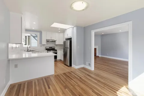 a kitchen with stainless steel appliances granite countertop a refrigerator and a sink