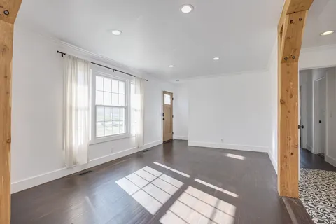 wooden floor in an empty room with a window