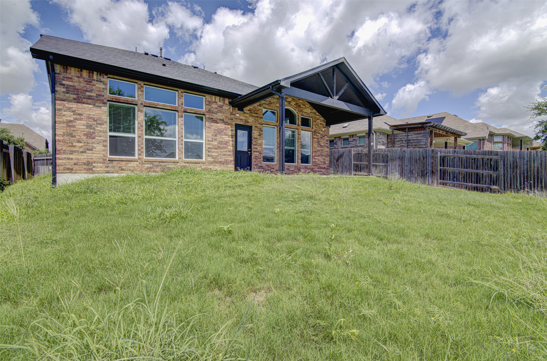774 Cherrystone Loop Buda, TX 78610 - Photo 33 of 38 A spacious backyard with mature grass offers ample room for outdoor activities.