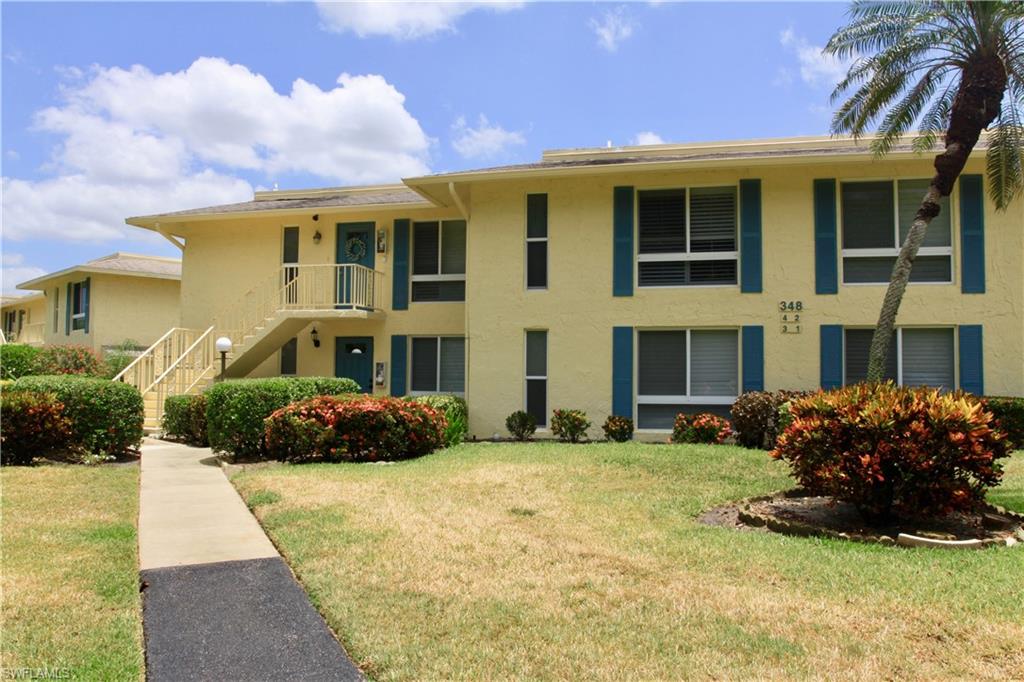 348 Tern Drive, Unit 4 Naples, FL 34112 - Photo 13 of 26 a front view of a house with a yard and garage