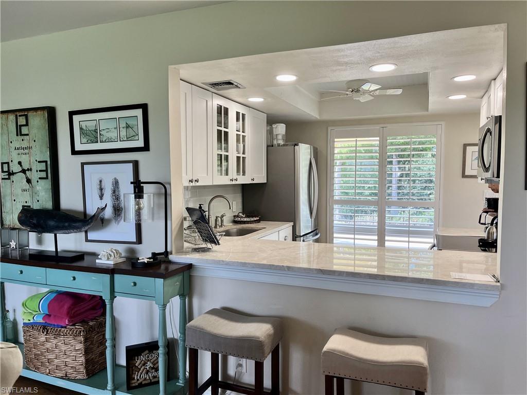 348 Tern Drive, Unit 4 Naples, FL 34112 - Photo 4 of 26 a kitchen with stainless steel appliances granite countertop a sink and a refrigerator