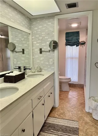 a spacious bathroom with a double vanity sink toilet and shower