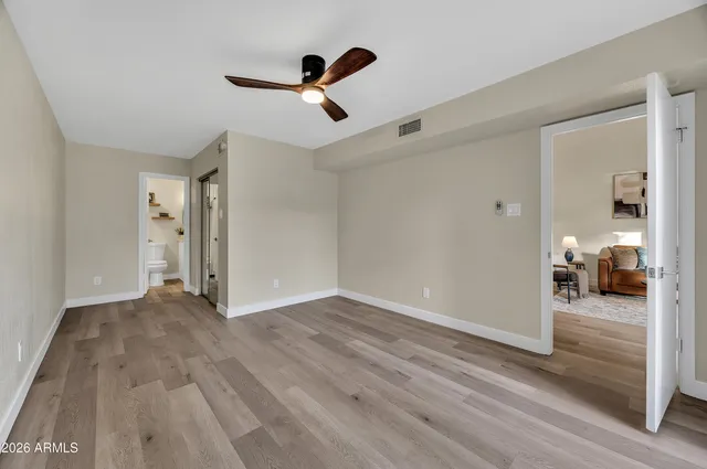 a view of a livingroom with wooden floor and a ceiling fan