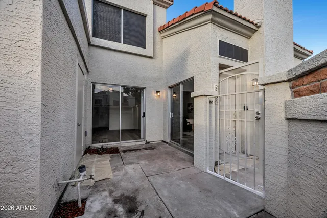 a view of a house with a yard and potted plants
