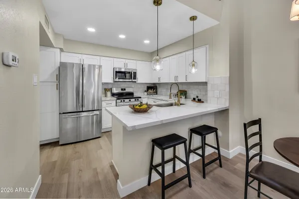 a kitchen with kitchen island a white counter top space cabinets and stainless steel appliances