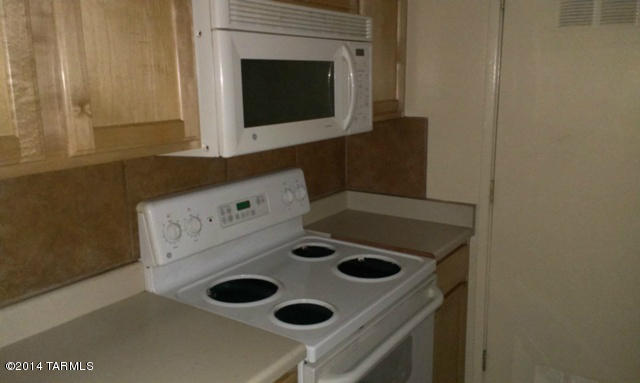 625 South Prudence Road, Unit 108 Tucson, AZ 85710 - Photo 7 of 20 a kitchen with a stove and a microwave