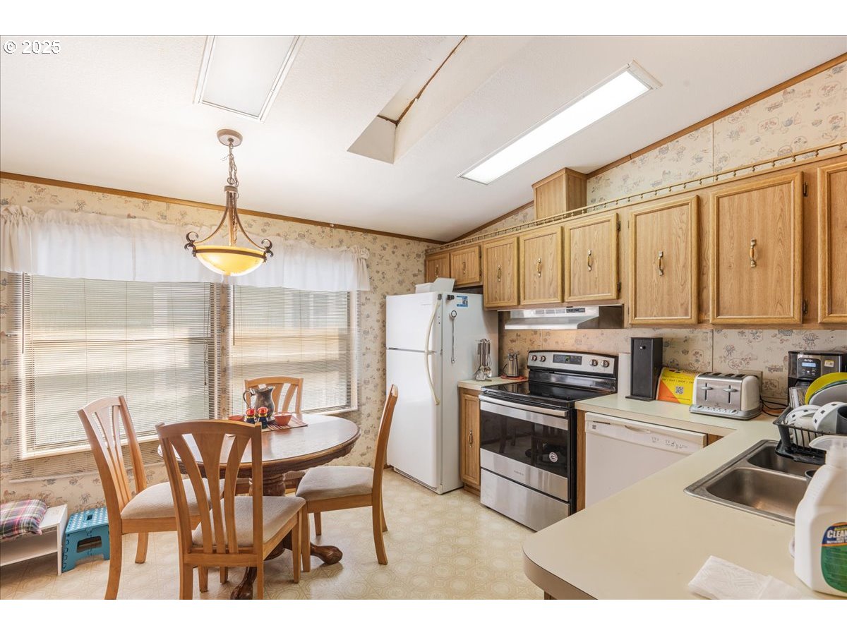 300 Southwest 7th Avenue, Unit 302 Battle Ground, WA 98604 - Photo 11 of 41 a kitchen with stainless steel appliances kitchen island granite countertop a table chairs and a refrigerator