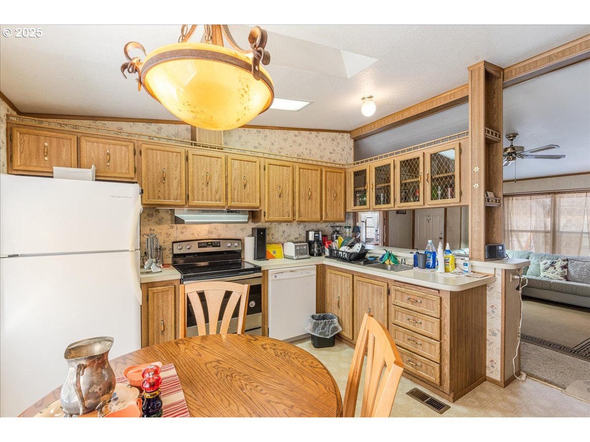 300 Southwest 7th Avenue, Unit 302 Battle Ground, WA 98604 - Photo 14 of 41 a kitchen with a stove a refrigerator and a dining table