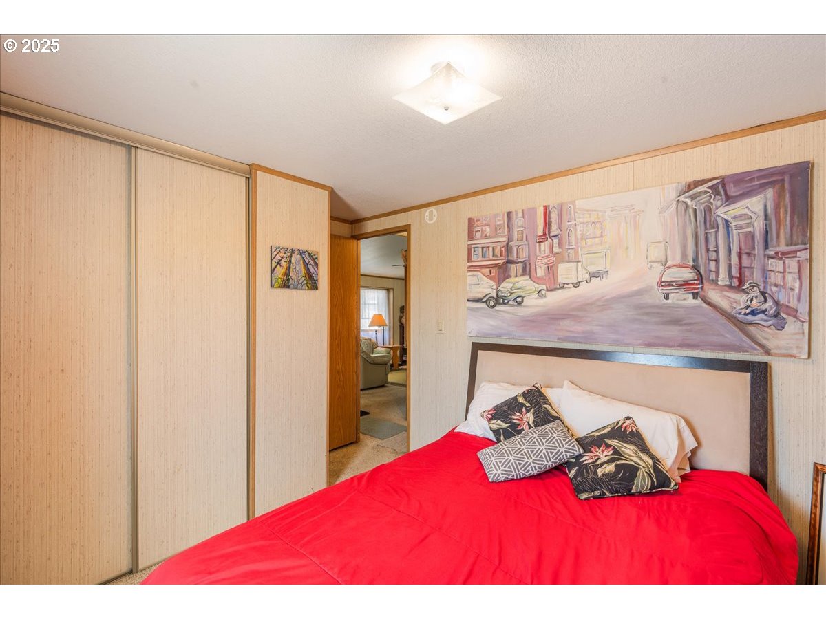 300 Southwest 7th Avenue, Unit 302 Battle Ground, WA 98604 - Photo 25 of 41 a bedroom with a bed window and walk in closet with wooden floor