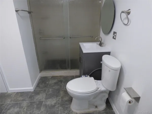 a white toilet sitting next to a bathroom sink and a shower