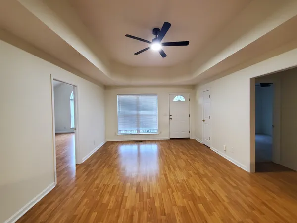 an empty room with wooden floor and windows
