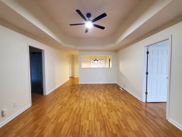 an empty room with wooden floor and windows