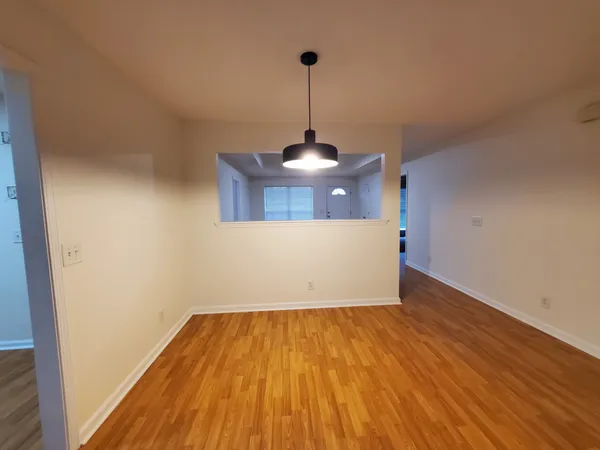 a view of a room with wooden floor and white walls