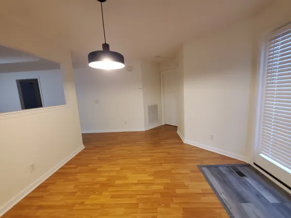 a view of empty room with wooden floor