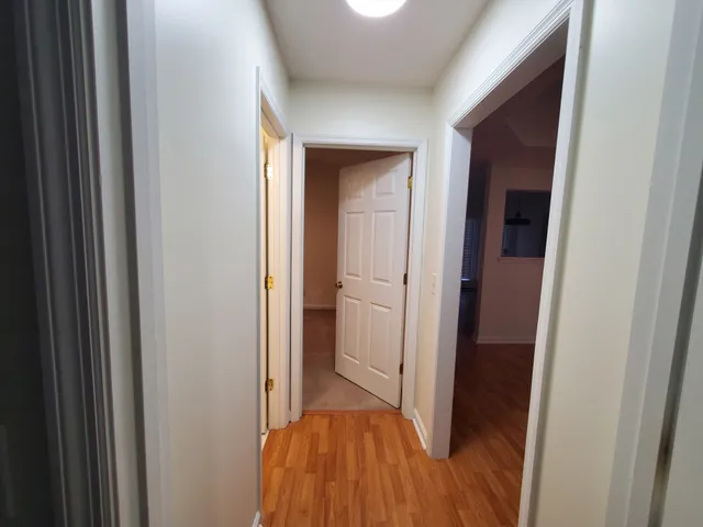 a view of a hallway with wooden floor