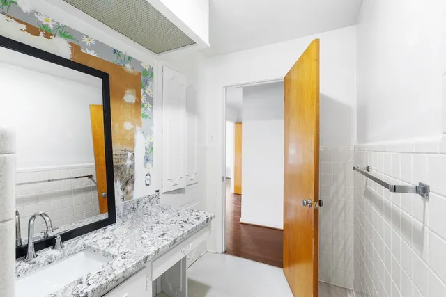 a bathroom with a granite countertop sink and a mirror