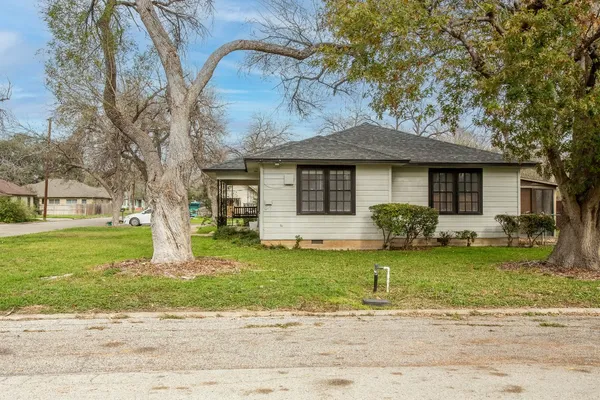 a front view of a house with a garden