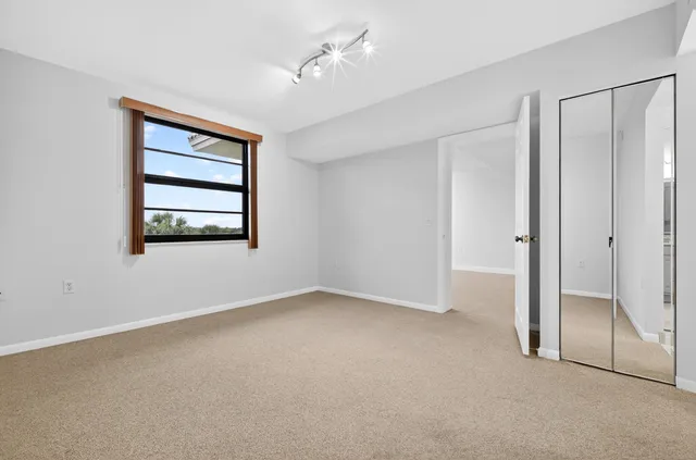 an empty room with windows and closet