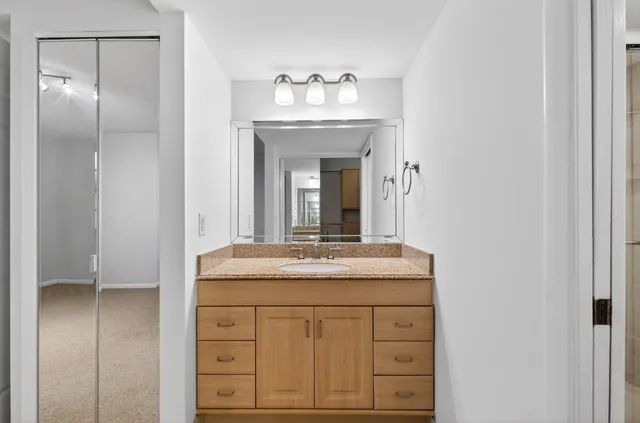 a bathroom with a granite countertop sink and a mirror